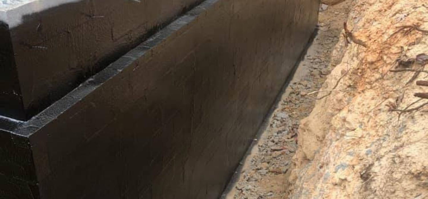 Exterior foundation waterproofing membrane applied to a home's foundation wall to prevent moisture intrusion and improve drainage.